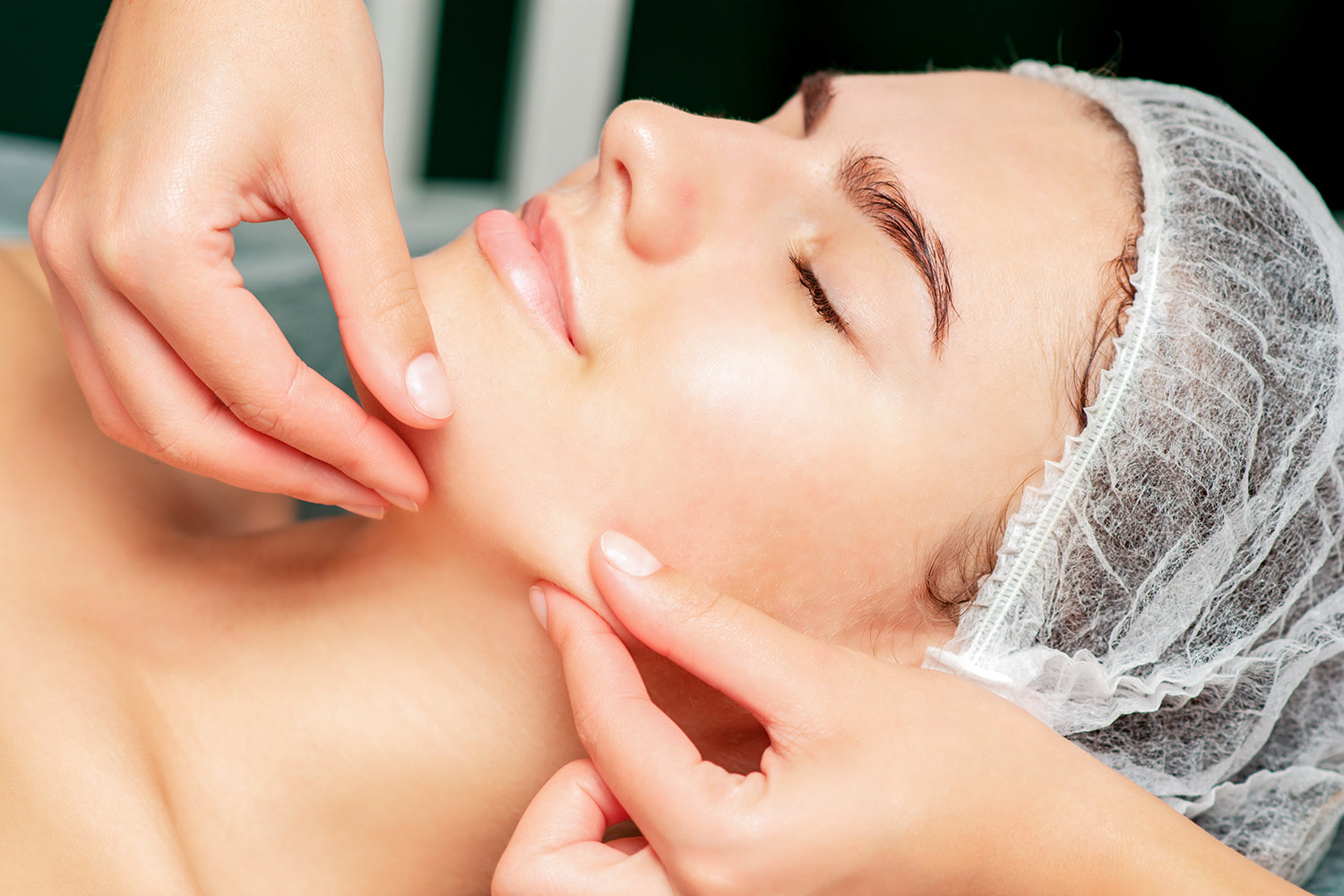 Woman receiving a lymphatic drainage facial massage